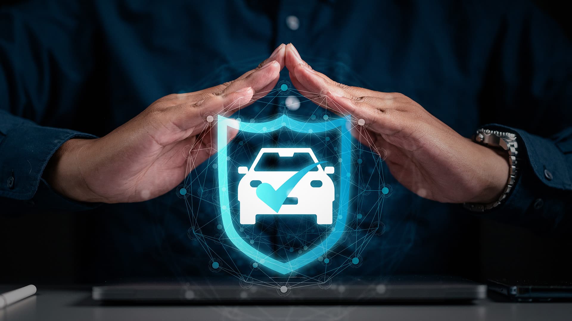 A pair of hands over an image of a shield around a car, representing auto transport insurance
