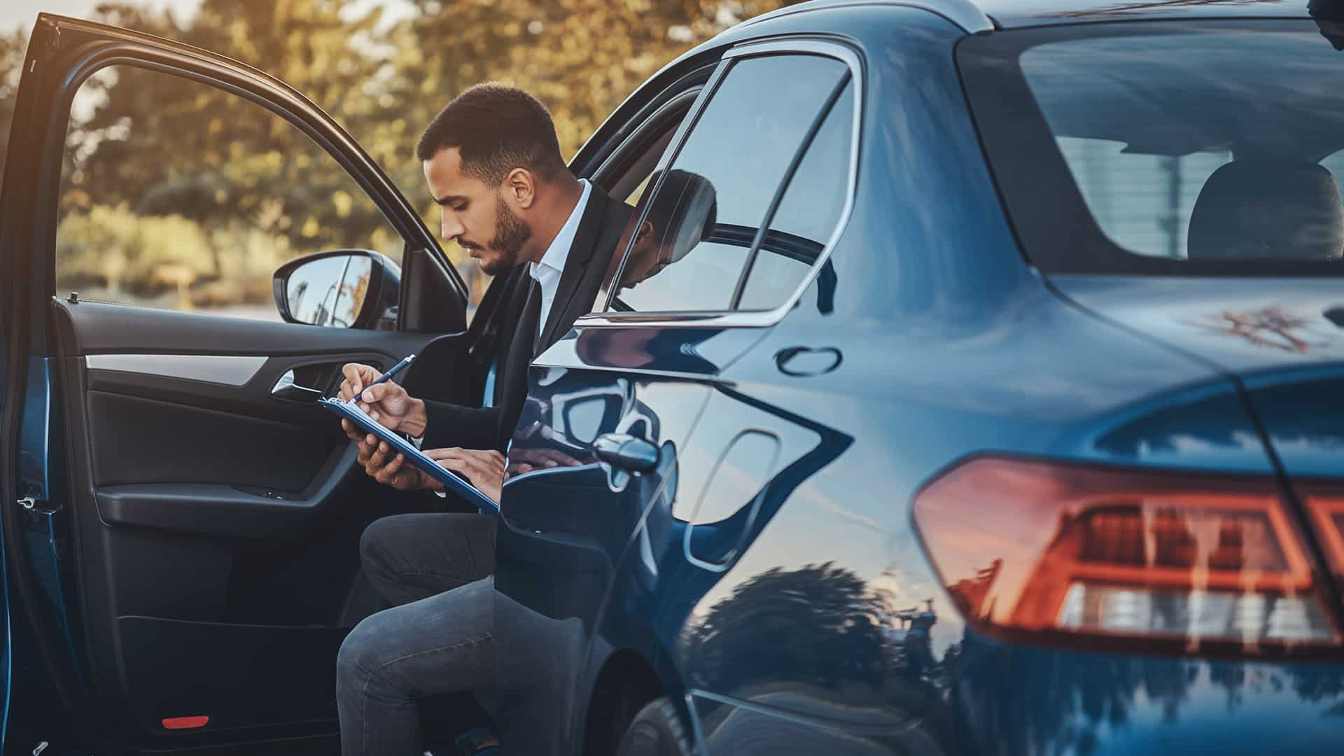 Man with a clipboard checking the value of the car.